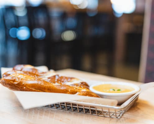 Toasted, buttered and salted Bavarian pretzel sticks. Topped with green onion and served with our in-house beer mustard cheese sauce. | Cal 850