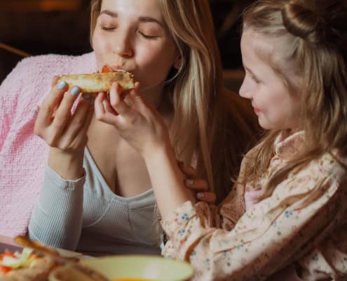 Mom eating her daughter's pizza at Ruby's Pizzeria & Grill